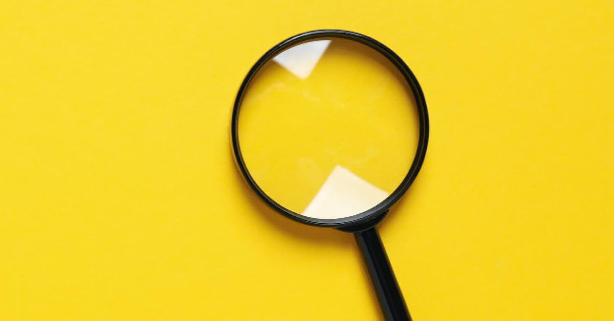 Giant magnifying glass on a yellow surface 