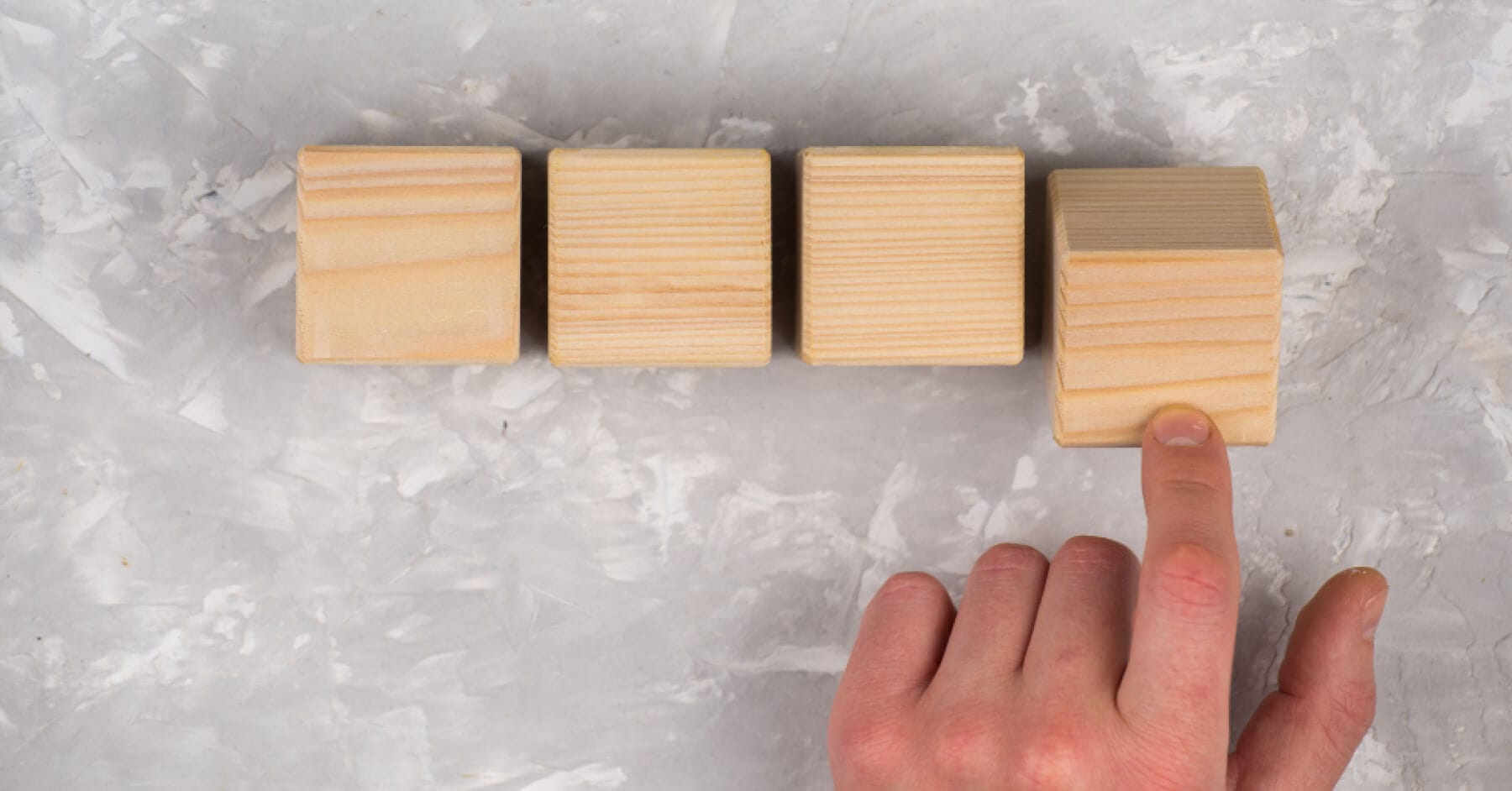 Hand arranging four wooden blocks symbolizing role-based interview report examples.