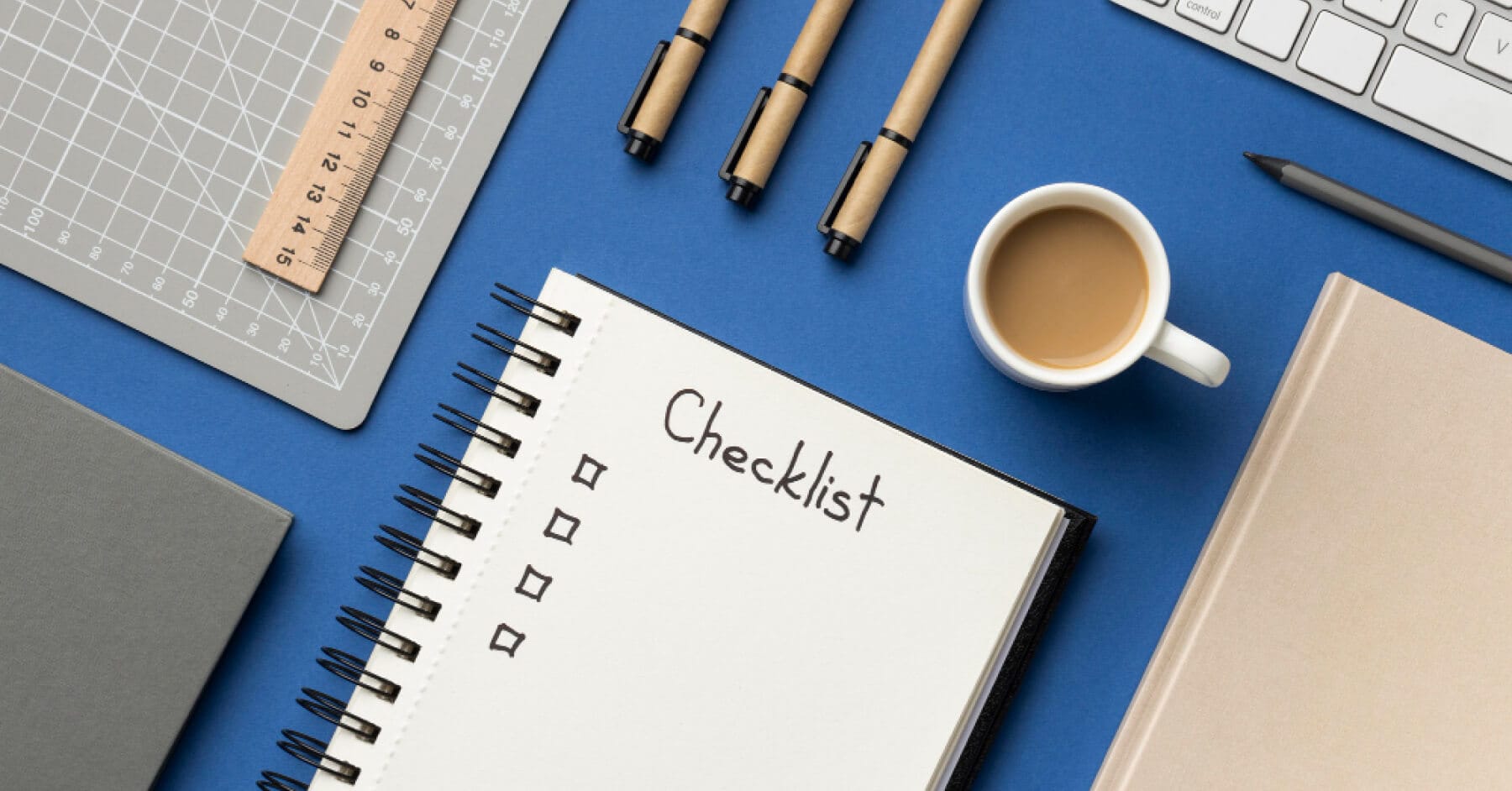 Desk with checklist notebook, pens, and coffee cup symbolizing bias-free interview report preparation.