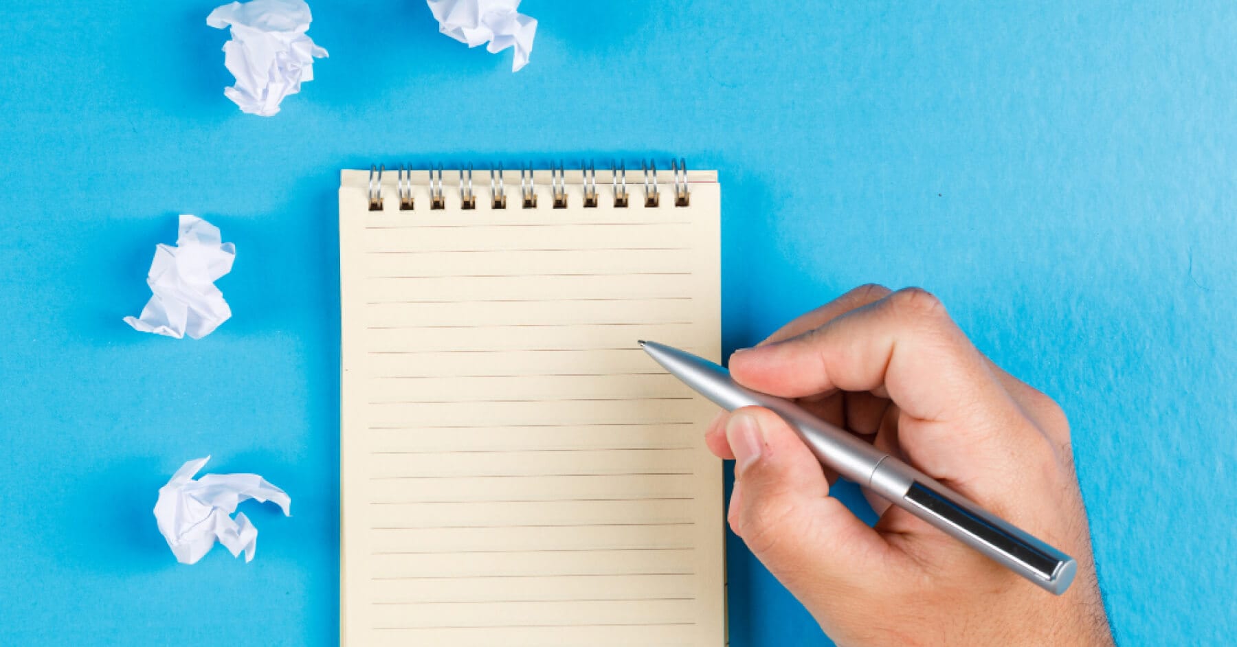 Person writing notes in a notebook while preparing an interview report