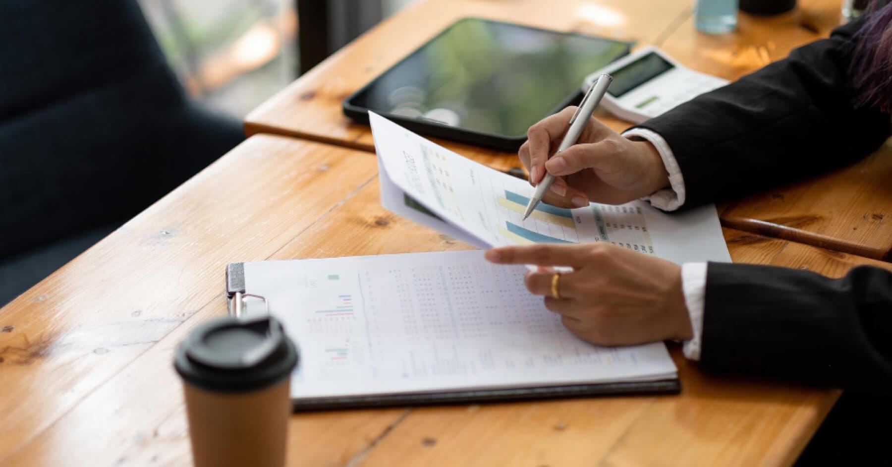 Recruiter reviewing interview report charts and candidate evaluation data at a desk
