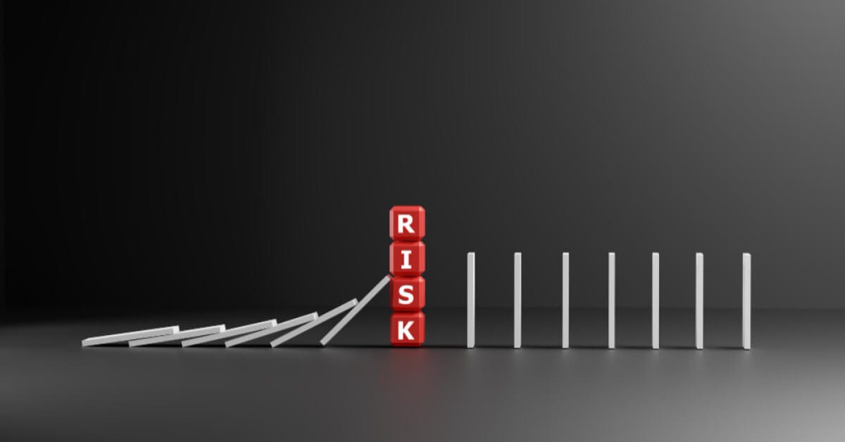 a domino falling on blocks saying RISK